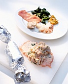 Close-up of veal rolls being prepared and wrapped in aluminium foil