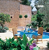 Südländische Terrasse mit Pool, gedeckter Gartentisch + Flechtstühle