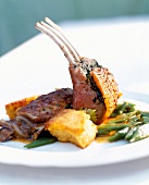 Braised rack of lamb with beans and fried polenta on plate