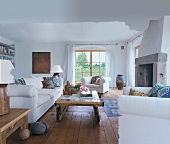 Wohnzimmer mit weißen King Size Polstermöbeln,Holztisch,Dielen,Kamin