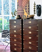 African decorations on narrow chests drawers made of cherry wood
