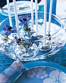 Glasschale mit Wasser und schwimmenden Kerzen und Blüten
