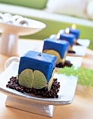4 blaue Kerzen auf Silberschale verziert mit Blättern und Golddraht