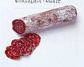 Sliced salami of wild boar on white background