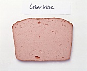 Slice of liver cheese on white background