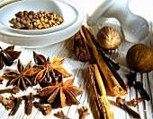 Cinnamon, star anise, nutmeg, coriander, allspice and cloves on wooden surface