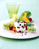 Romaine lettuce with goat cheese, pumpkin seeds and raspberries on plate