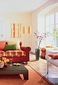 Teilansicht eines Raumes in warmen Farben, Sofa, Bodenvase m. Zweig