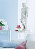 Steinstatue auf Eisentisch im pastell Raum, hellblau, rosa