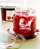 Cherry and vanilla jelly in open glass jar