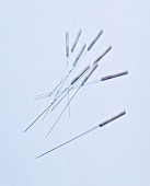 Variety of acupuncture needles on white background