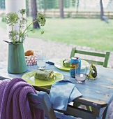 Lunchgedeck auf blau lasiertem Holztisch im Garten
