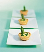 Tarts with asparagus on square plates