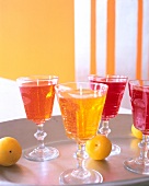 Close-up of transparent goblets of gel wax candles in fruit colours