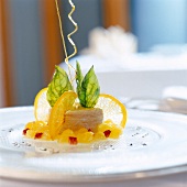 Basil mousse with candied orange slices on plate