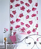Wandbehang mit rosa Papageientulpen im Schlafzimmer überm Bett