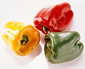 Close-up of red, yellow and green bell peppers on white background