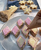 Plätzchen mit rosa Puderzuckerguss verziehren, Spritztütchen