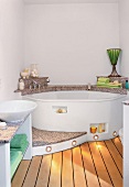 Badezimmer mit Whirlpool auf Podest aus Granit, Holzdielen