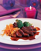Close-up of venison fillet with anise, carrots and broccoli on plate