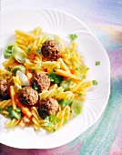 Close-up of vegetables fusilli with meatballs on plate