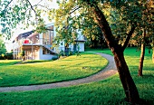 Blick vom Garten auf ein weißes, neues Wohnhaus