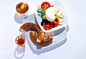 Breakfast table set with salad, sheep cheese, tea, honey and sesame bread on plate