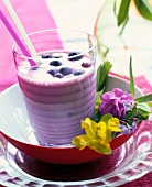 Glass of smoothie with milk and blueberries