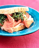 Close-up of sandwich with tomato, parma ham, cream cheese and cress on plate