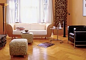 Wohnzimmer im Ethno-Stil mit Sofa, Hocker, Beistelltisch, Ledersessel
