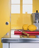 Edelstahl- Arbeitsplatte mit zwei Zitronen auf rotem Brett