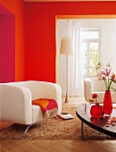 Sofa beige, Wand orange rot, Teppich Stehlampe, Blumenvasen, Couchtisch