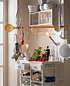 Kitchen in white with cooking utensils hanging on long spoon