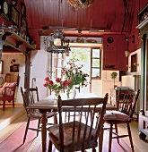 Antique dining table and chairs with flower vase on it