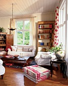 Wohnzimmer, Sommerhaus,  mit hellem Sofa, Bücherregal, Couchtisch