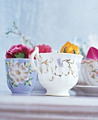 Porzellantassen, mit Blüten gefüllt