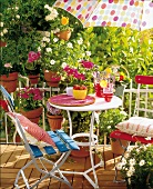 Chairs, table and parasol on balcony with potted plants