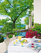 Balkon, mediterran, Karaffe, Gläser auf weißem Holztisch, Blick in Ferne