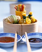 Asian snacks on wooden bowl with two different sauces in china bowls with chopsticks