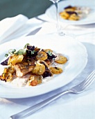 Close-up of champagne tripe with fried walleye fillet and black pudding on plate