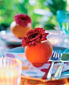 Orange und Gerbera als Tischdeko auf gepunkteter Serviette