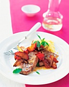 Tuna steak with plums and mint leaves served on plate