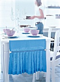 Blauer Tischläufer mit Falten und Knöpfen