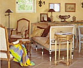 Helle Stühle mit goldener Verzierung und ein helles altes Sofa