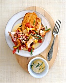 Turkey escalope with chanterelles in white plate on wooden platter, overhead view