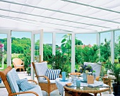 Conservatory house with wicker furniture and view of garden