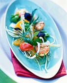 Salad with scallops, fennel, oranges and Ravioli in oval plate