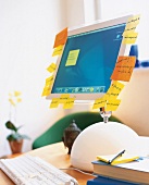 iMac mit Flachbildschirm und vielen Post its auf einem Schreibtisch
