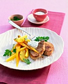 Pork tenderloin with vegetables and parsley cream in plate