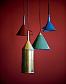 Funnel shaped pendant lights hanging against red background